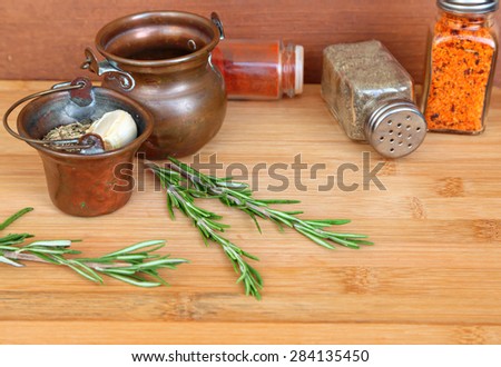 Natural blurred kitchen background of a various herbs and species on the wood. Selective focus on rosemary herb