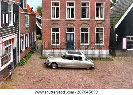 NETHERLANDS - OCTOBER,13, 2014 :Old authentic Dutch town Marken and retro auto parked in the street.Holland.Netherlands.Citizens of Marken are faithful to old traditions everywhere and in everything