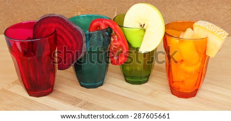 Various fresh vegetable and fruit juices and salads in a colorful glasses. Colorful healthy food and drinks. Summer fruit and vegetables. Kitchen wooden background