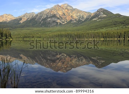 Reflection in smooth water of mountain lakes (Jasper National Park, Alberta, Canada)