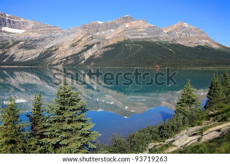 Reflection in smooth water of mountain lake (Banff National Park, Alberta, Canada)
