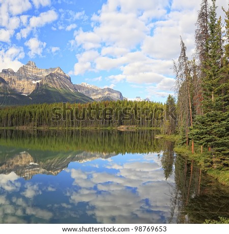 Herbert Lakes with reflection of the cloudy sky and snow mountains in a smooth water  (Banff National Park, Alberta, Canada)
