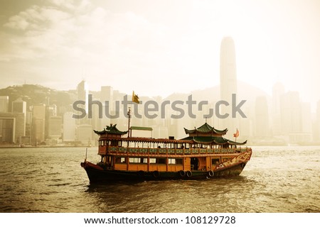 Hong Kong skyline with boats in Victoria Harbor in yellow tone.