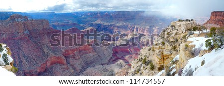 Grand Canyon panorama view in winter with snow and clear blue sky.