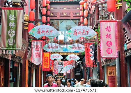 SHANGHAI, CHINA - MAY 30: Chenghuangmiao street with crowded stores and decorations on May 30, 2012 in Shanghai. It is the largest city by population in the world with 23 million in 2010