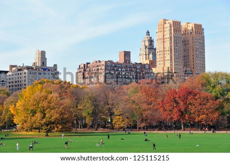 New York City Central Park at autumn in midtown Manhattan with colorful foliage and people on lawn