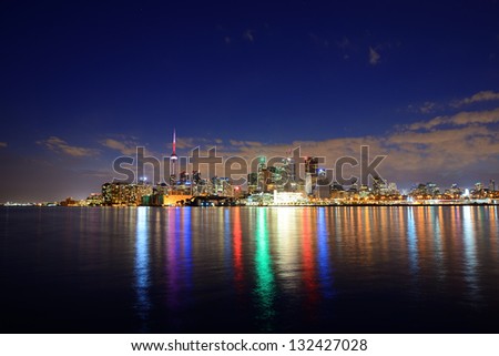Toronto cityscape panorama at dusk over lake with colorful light.