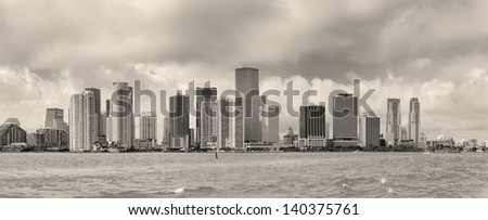 Miami skyline panorama in black and white in the day with urban skyscrapers and cloudy sky over sea