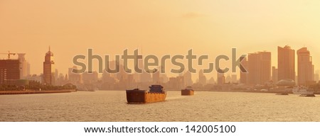 Boat with Shanghai city skyline silhouette panorama at sunset