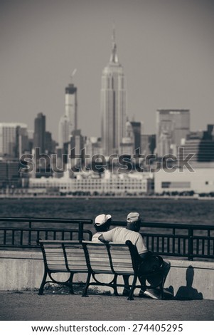Old couple sit at waterfront with Manhattan city view
