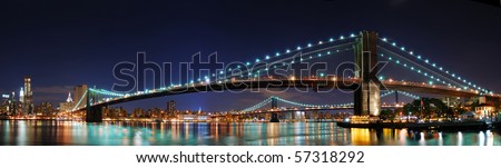 New York City Manhattan skyline panorama with Brooklyn Bridge and office skyscrapers building in at dusk illuminated with lights at night