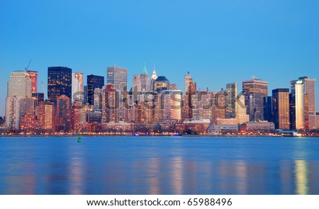 Manhattan Skyline at dusk, New York City, with lights in offices buildings over Hudson River.