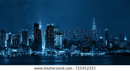 Manhattan midtown skyscrapers and New York City skyline panorama at night with fog