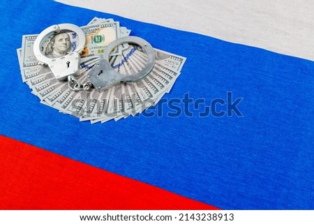 silver metal police handcuffs over paper dollar banknotes of United States of America over national flag of Russian Federation, concept of foreign currency prohibition Photo stock © 
