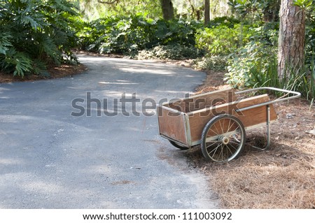 A lone garden push cart left on the side of the road