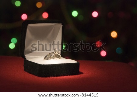 A beautiful 2 carat wedding ring in front of  Christmas tree lights with shallow DOF