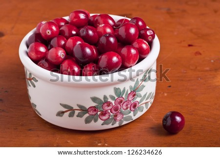 Ripe cranberries in a pottery dish.