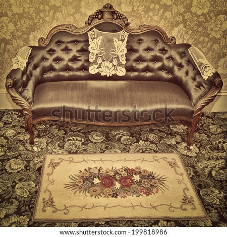 An antique sofa and hooked mat with a vintage sepia filter.