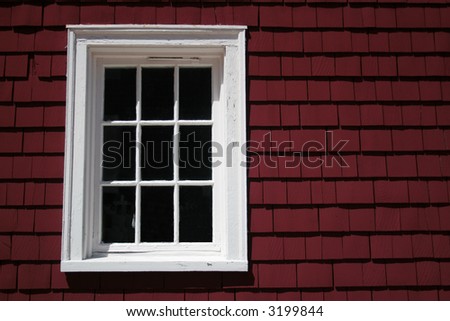 Rustic window on the side of a red historic building.
