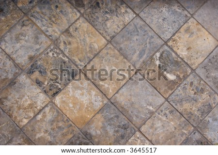 A tile floor made of complimentary earthtone shades of marble.