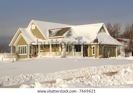 A contemporary home covered with freshly fallen snow.