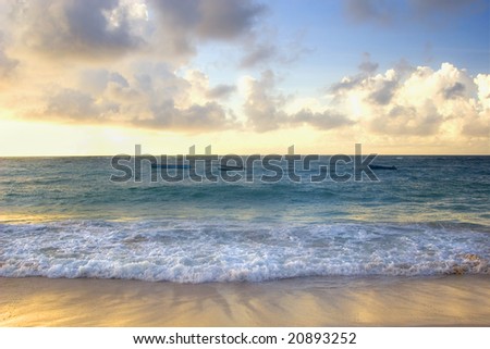 Boats bobbing in the ocean under the sunset of a Barbados beach.