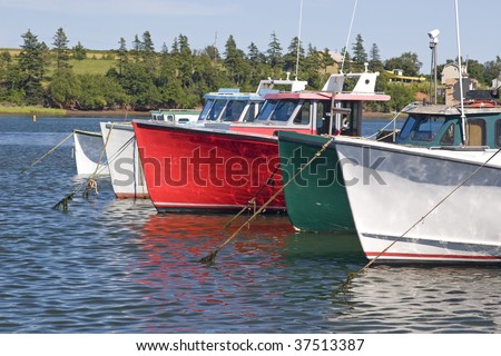 Commercial lobster fishing boats tied up off a wharf in Prince Edward Island, Canada.