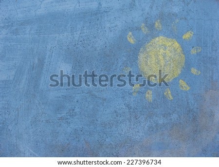 handpainted yellow sun on a blue grungy wall