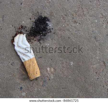 cigarette butt with ash showing shoe print