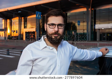 men hipster beard car parking airport terminal