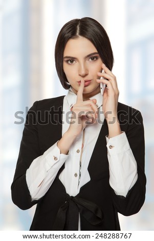 Young beautiful business woman holding talks with business partners on the phone in his office