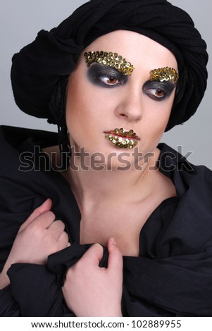Woman with black make-up and scarf on head