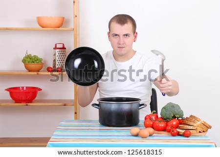 funny man cooking soup in the kitchen