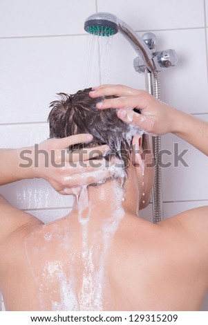man washing his hair in shower