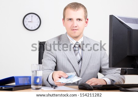 young business man giving money in bright office