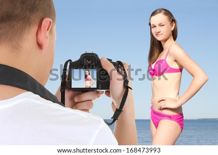 photographer with dslr camera taking picture of young beautiful woman on the beach