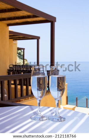 two glasses of champagne on balcony with sea view