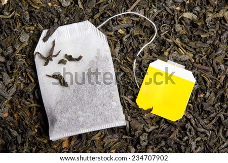 background with dried black tea and paper tea bag
