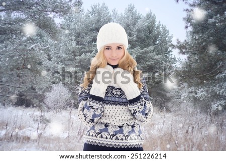 pretty woman in warm clothes posing in winter forest