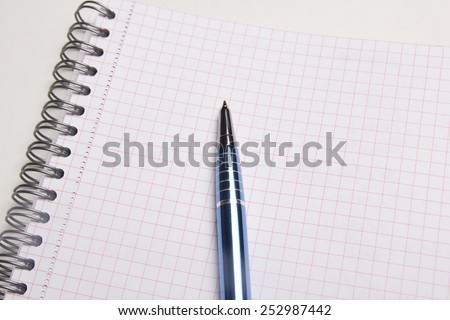close up of pen on blank note book with checked pages