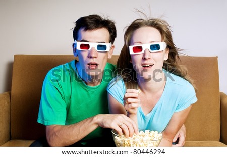 The surprised man and the woman watch TV