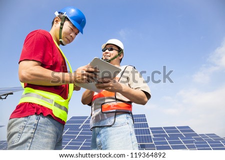 two workers  discussing with tablet pc before  solar power station
