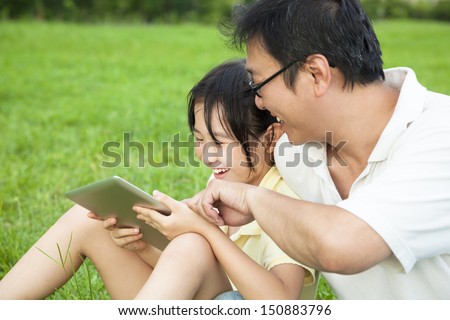father teaching  little girl using tablet pc