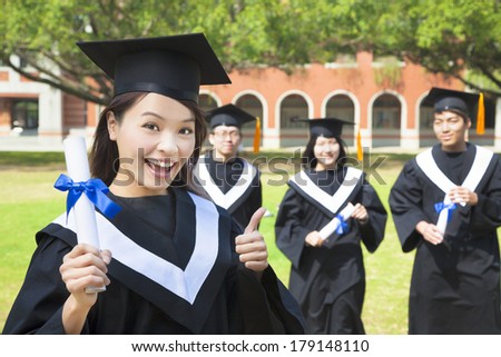 smiling college graduate holds a diploma and thumb up