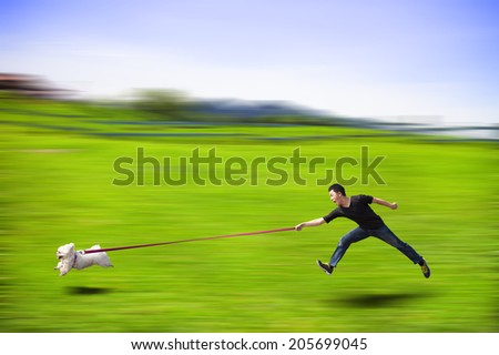 disobedient dog running fast and dragging a man by the leash