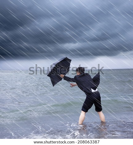 business man holding a umbrella to resist rainstorm