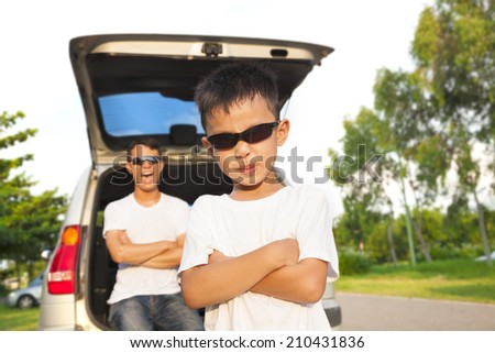 cool boy and father across arms with their car
