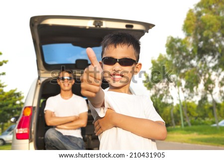 cool boy thumb up and father across arms with car