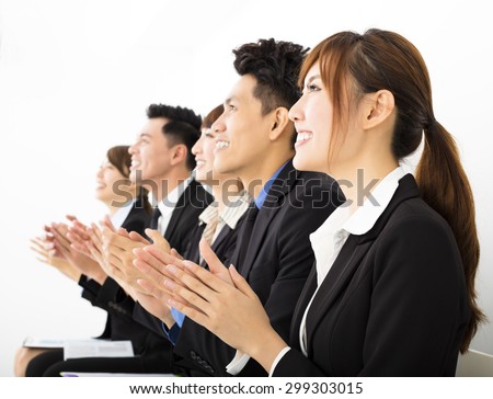 Business people sitting in a row and applauding