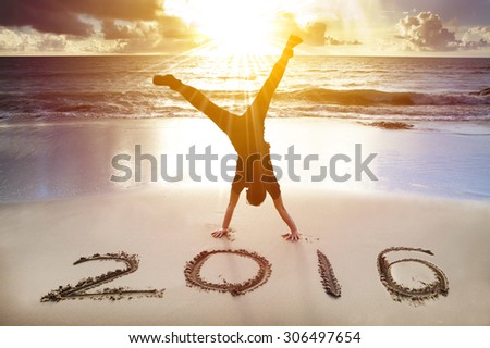 happy new year 2016. young man handstand on the beach
